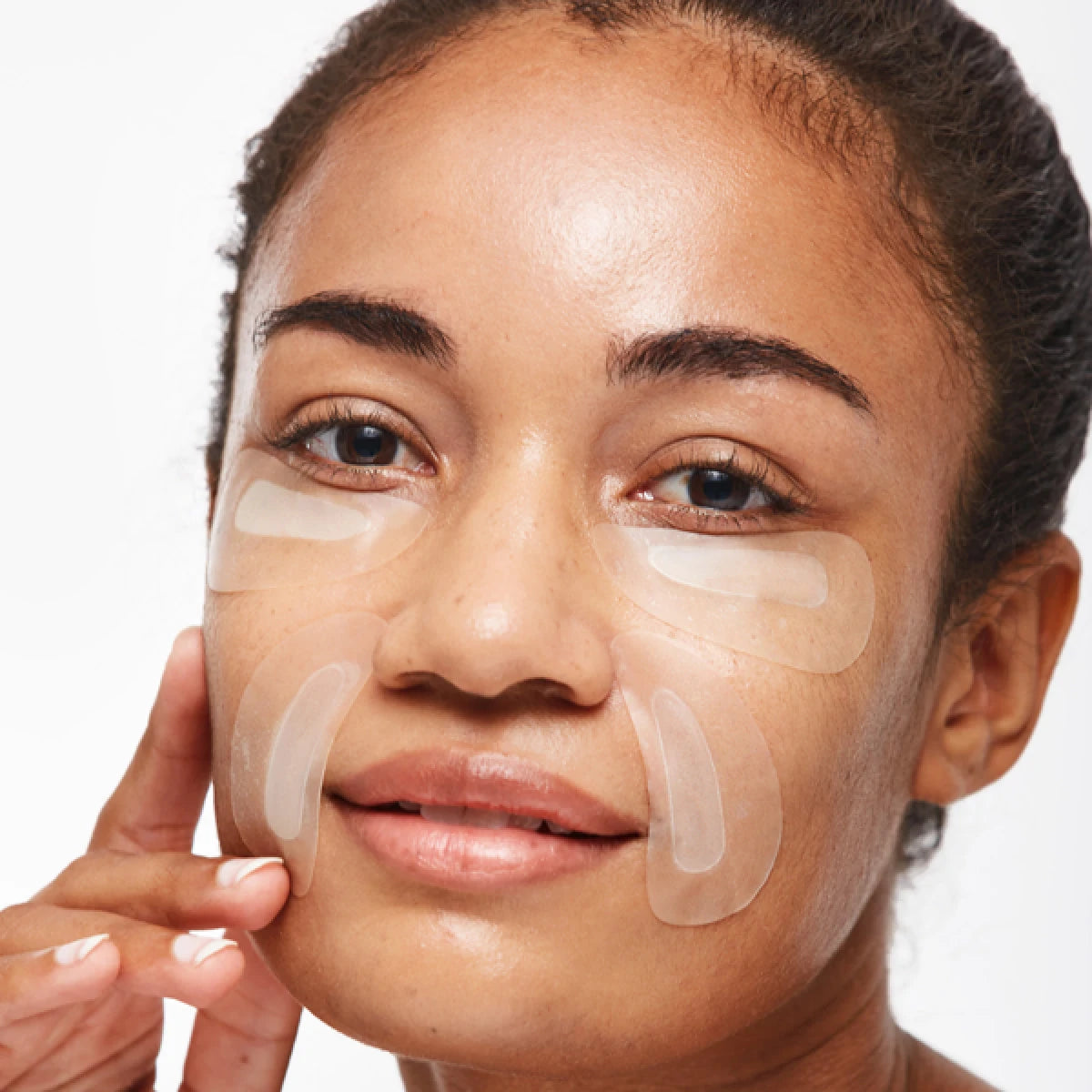 Woman with under-eye patches on a white background